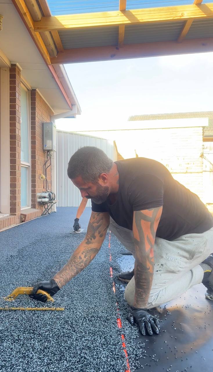 Mitchell, owner of Rubber Floor Solutions, hand-finishing a pour on site